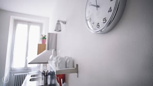 A kitchen with a white countertop, a sink, and a clock on the wall. - Italianway   - C.so Sempione 96 (Milan)