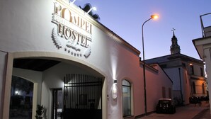 A building with a sign reading "POMPEI HOSTEL" and a gated entrance.
