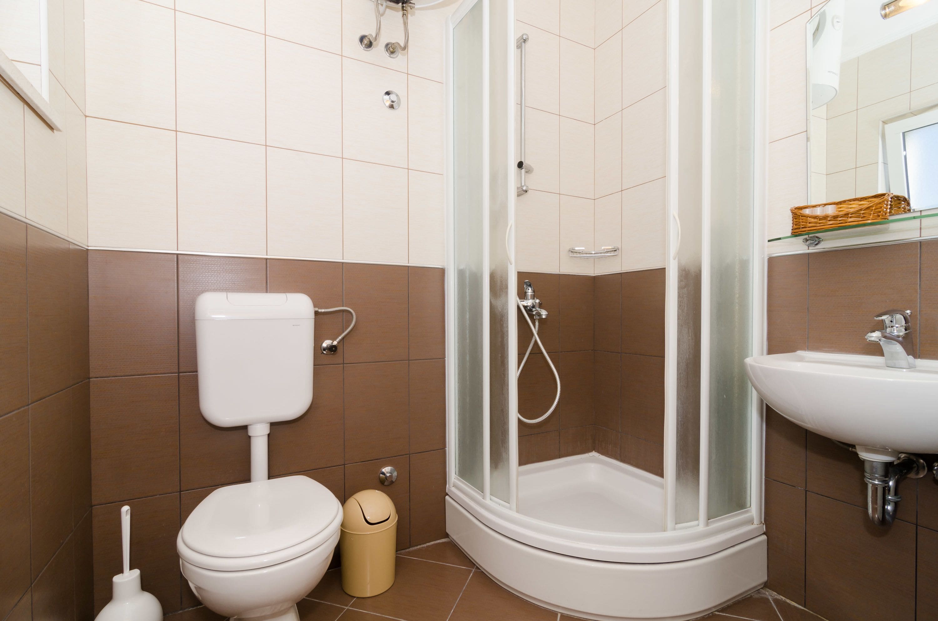 A bathroom with a toilet, bidet, and a glass-enclosed shower.