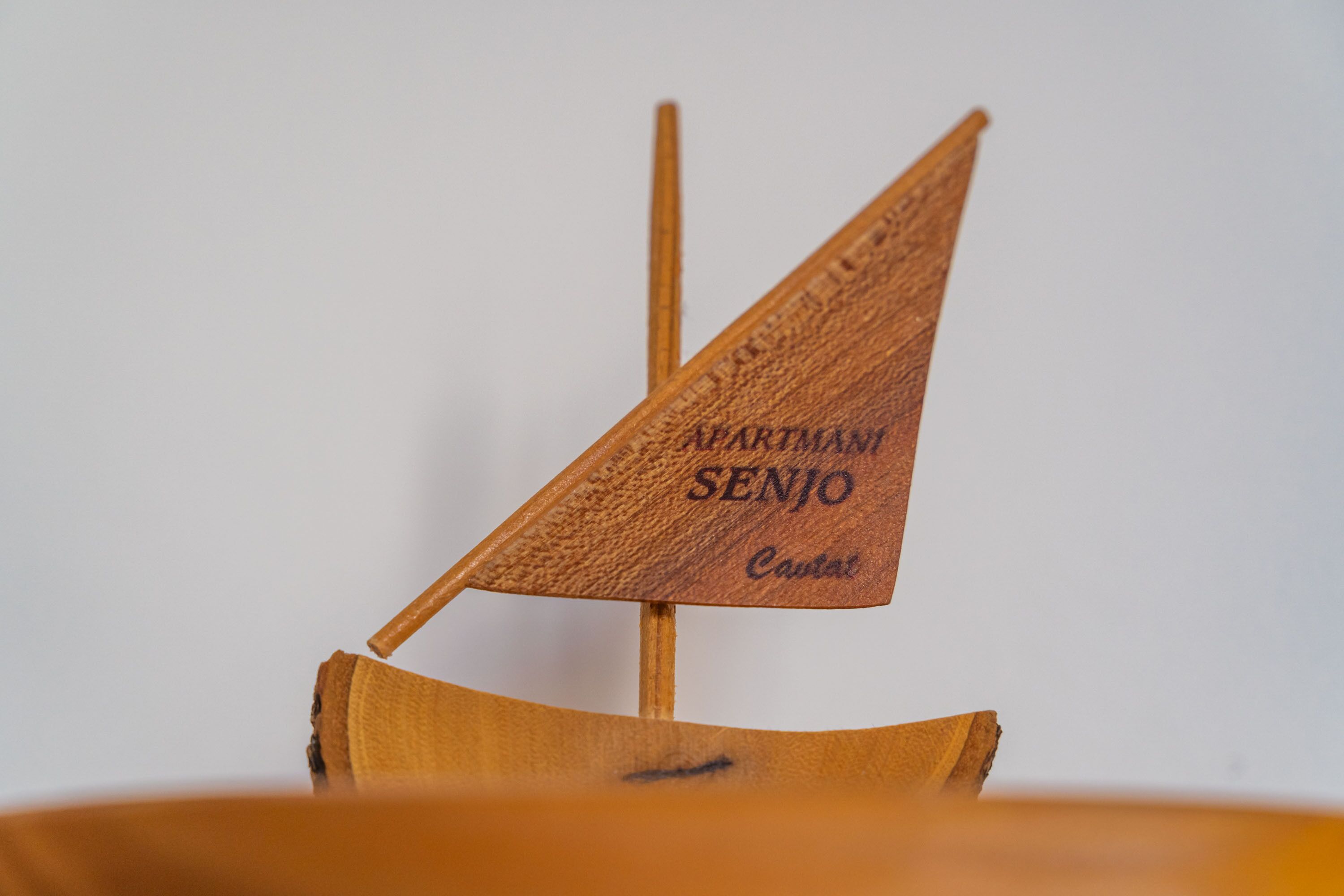 A wooden model ship with the inscription "ARTMAN SENJO Captain".