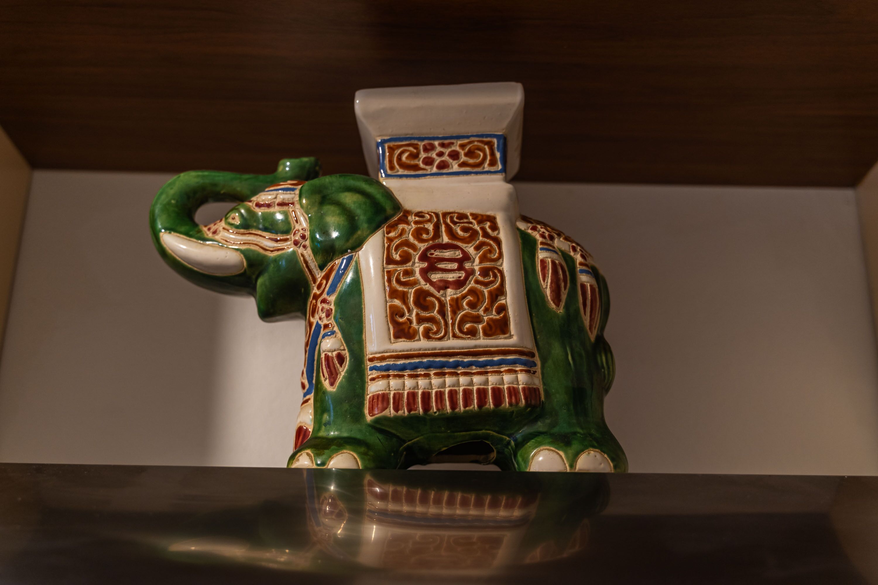 Una figurita de elefante de cerámica con diseños intrincados.