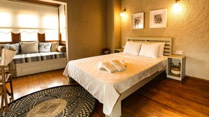 Een gezellige slaapkamer met een groot bed, een bank met kussens en een klein tafeltje.