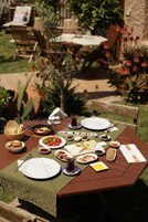 Mesa de comedor al aire libre con diferentes platos y un menú.
