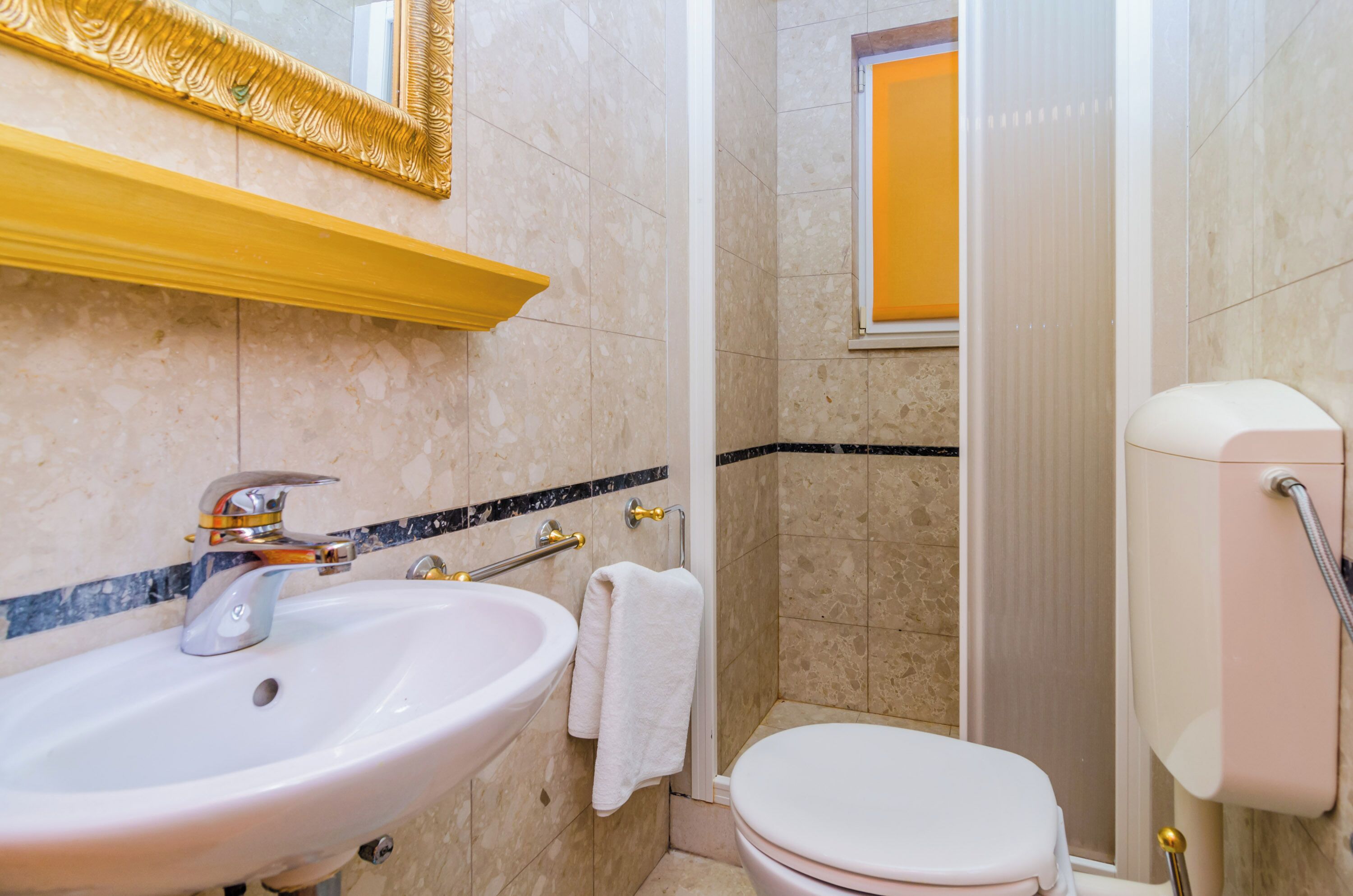 Un baño con lavamanos, inodoro y ducha.