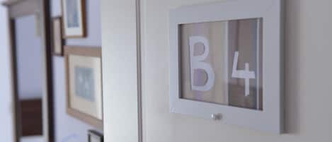 Una pared con letras enmarcadas 'B4' y varias fotografías enmarcadas.