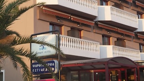 Un hotel con varios balcones, un cartel del Hotel Canari y un cartel de una discoteca.