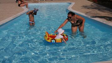 Una piscina al aire libre, sombrillas, tumbonas