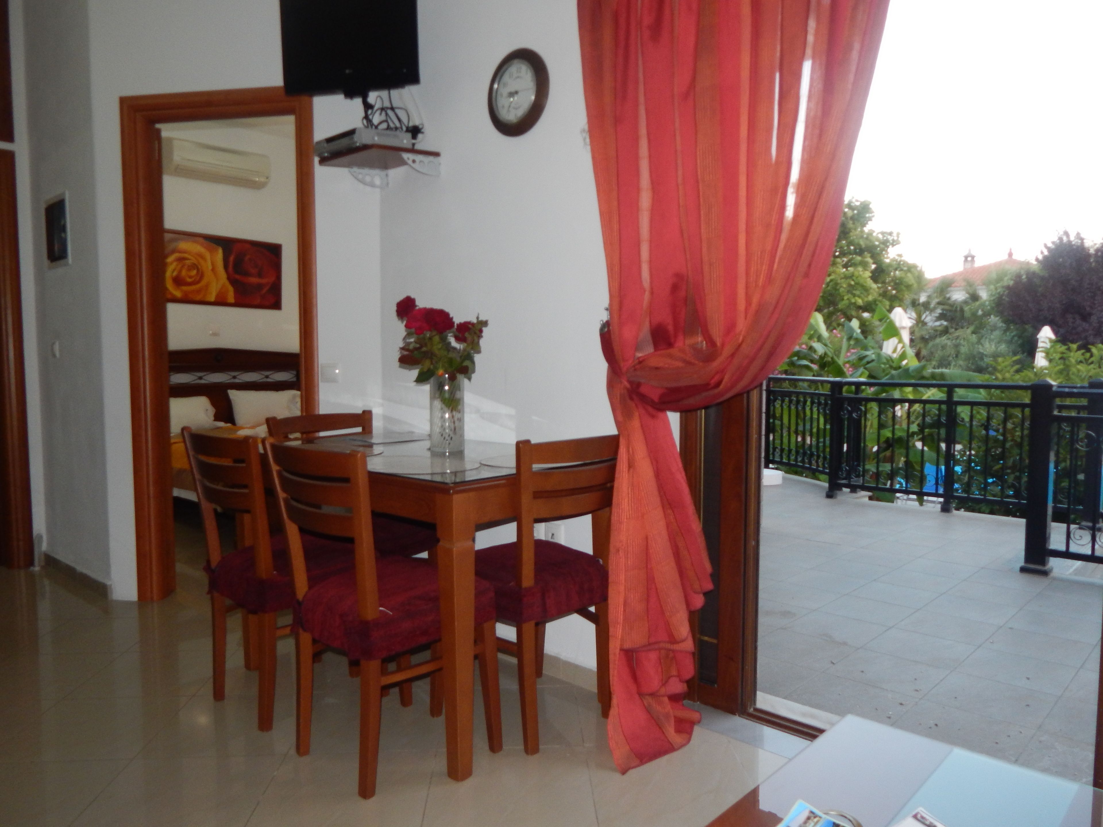 A dining area with a table, chairs, and a vase of flowers.