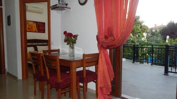 A dining area with a table, chairs, and a vase of flowers.