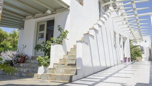 Un edificio blanco con escalones de piedra y un corredor cubierto.