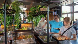 Ein Buffetbereich mit verschiedenen Speisen und einer Person, die Essen ausgibt.