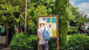 Un homme se tient devant un panneau d’affichage où sont accrochés divers panneaux d’information.