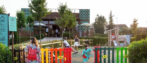 A playground area with a slide and a fenced entrance.