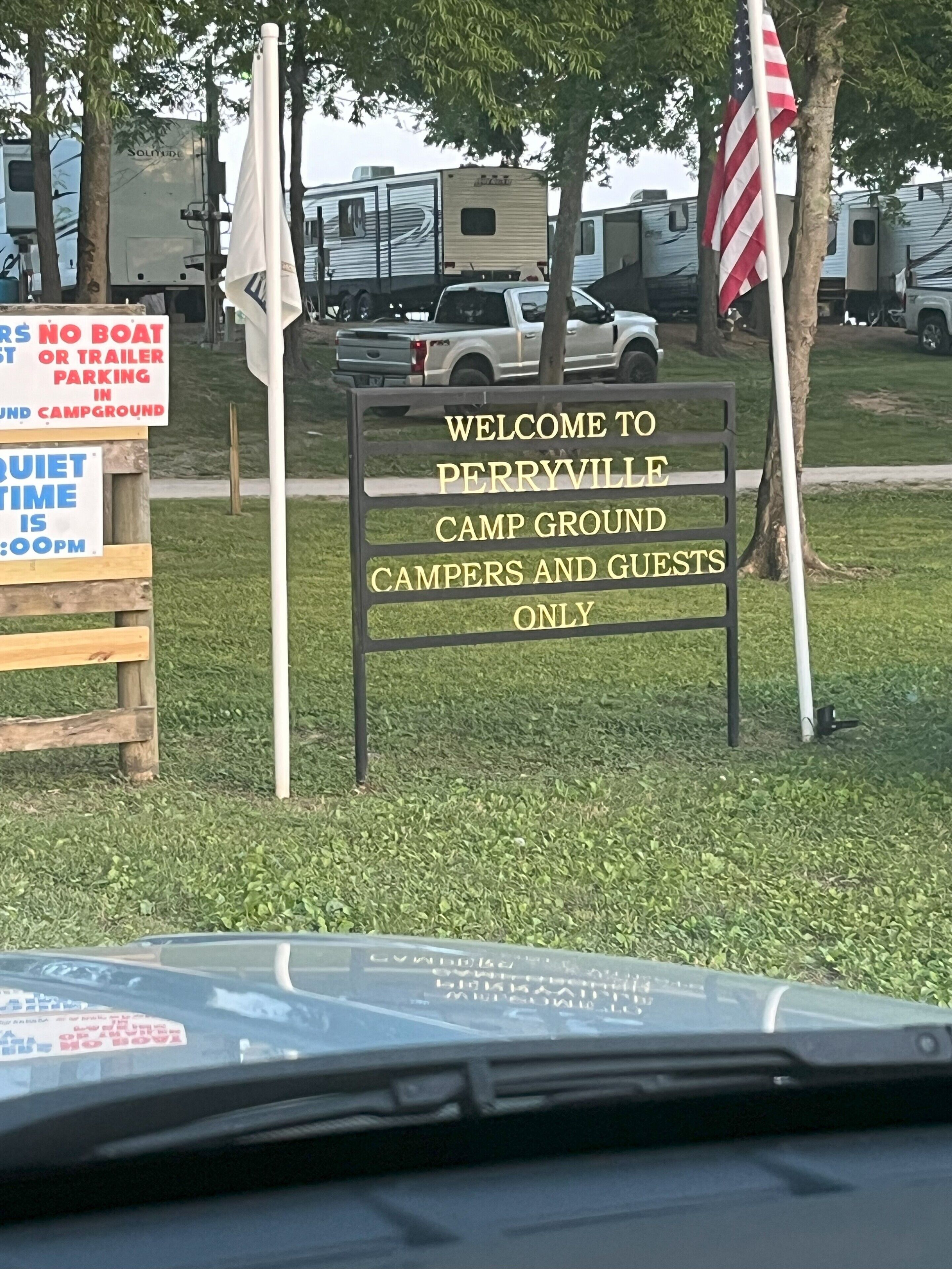 Willkommensschild für den Perryville Campground, mit einem Verbotsschild für parkende Boote und einer Information zu Ruhezeiten.