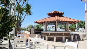 An outdoor seating area with white chairs and a covered gazebo. - Dias studios (Apokoronas)