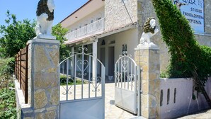 A building with stone walls, a balcony, and a sign that reads "Studios Enoikia Zomena". - Dias studios (Apokoronas)