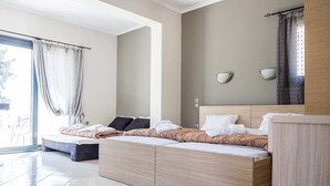 A modern bedroom with a large bed, a wooden headboard, and a large window with curtains.