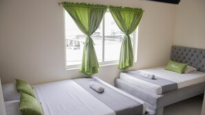 Une chambre d’hôtel avec deux lits simples, chacun étant équipé d’un oreiller et d’une serviette.