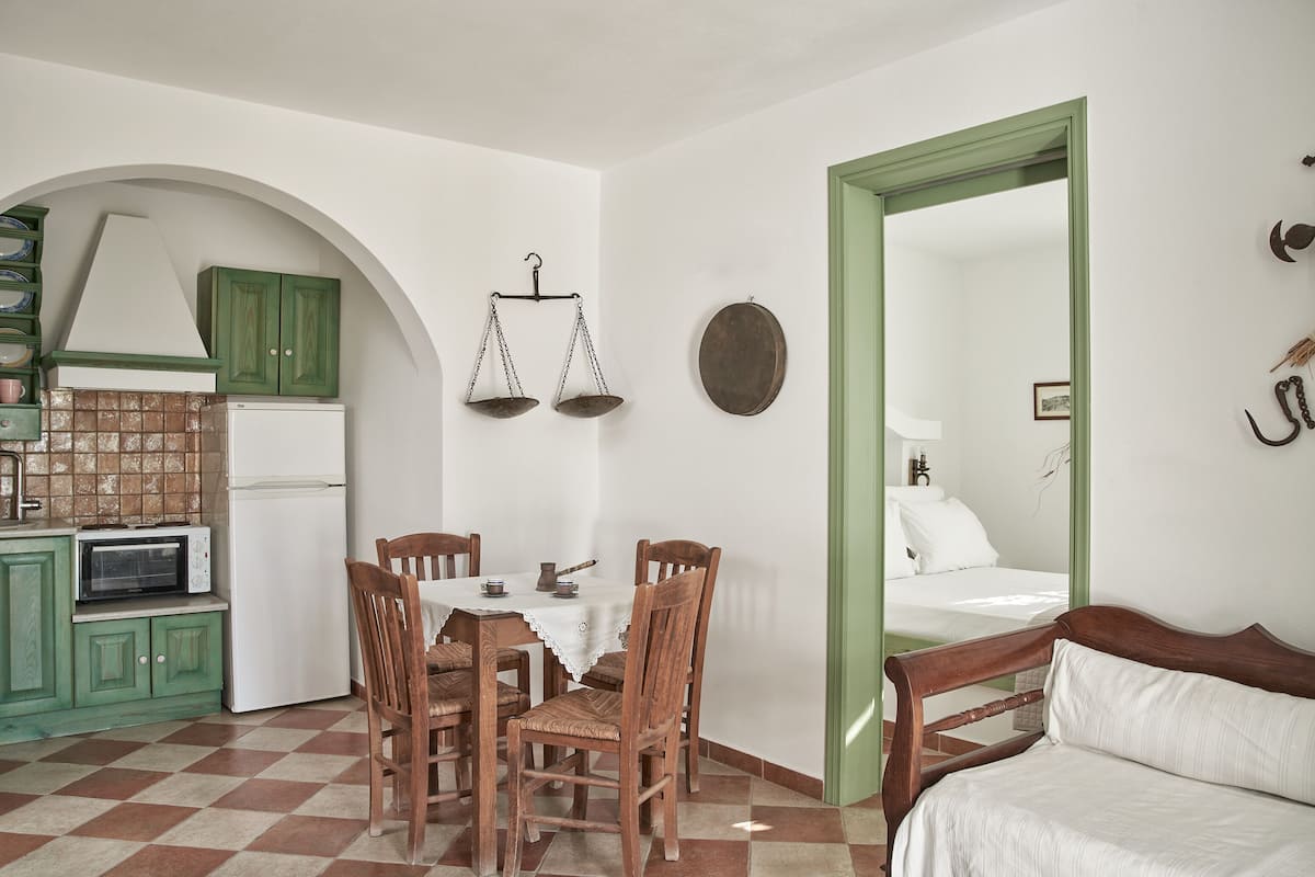 A dining area with a table, chairs, and a view into a bedroom.