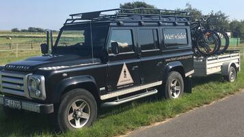 Ein schwarzer Land Rover mit Fahrradträger und einer Website-Adresse an der Seite.