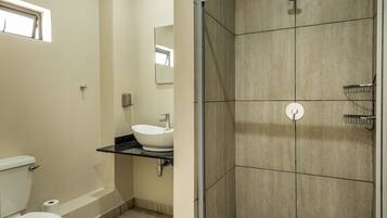 Een moderne badkamer met toilet, wastafel en douche.