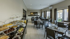 A buffet-style breakfast area with multiple serving stations and tables set for dining. - Pofadder Inn by Country Hotels (Khâi-Ma)