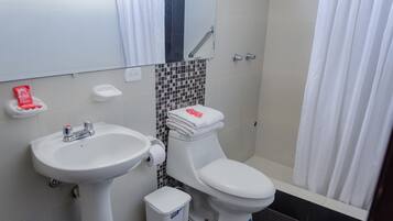 A bathroom with a white sink, toilet, and shower curtain.