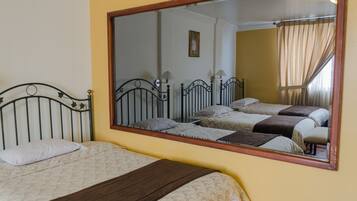 Een kamer met twee bedden, een grote spiegel en een ingelijst kunstwerk aan de muur.