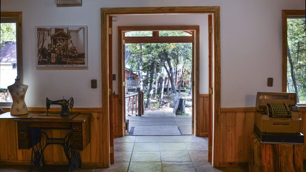 A wooden interior with a door leading to an outdoor area with trees. - Hotel Borde Andino (Pinto)