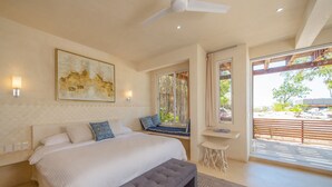 Un dormitorio con una cama grande, un banco, un escritorio y una ventana con vistas al exterior.