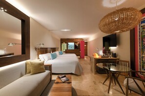 A hotel room with a sofa, a bed, a dining table, and a TV. - Hotel Xcaret Mexico - All Parks / All Fun Inclusive - All inclusive (Playa del Carmen)