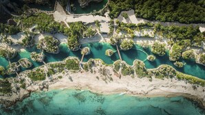 An aerial view of a coastal area with clear turquoise waters, sandy beaches, and lush greenery. - Hotel Xcaret Mexico - All Parks / All Fun Inclusive - All inclusive (Playa del Carmen)