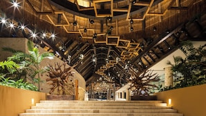 A grand staircase with wooden railings and a high ceiling with hanging lights. - Hotel Xcaret Mexico - All Parks / All Fun Inclusive - All inclusive (Playa del Carmen)