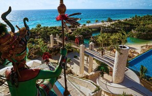 A resort with a pool, palm trees, and a view of the ocean. - Hotel Xcaret Mexico - All Parks / All Fun Inclusive - All inclusive (Playa del Carmen)