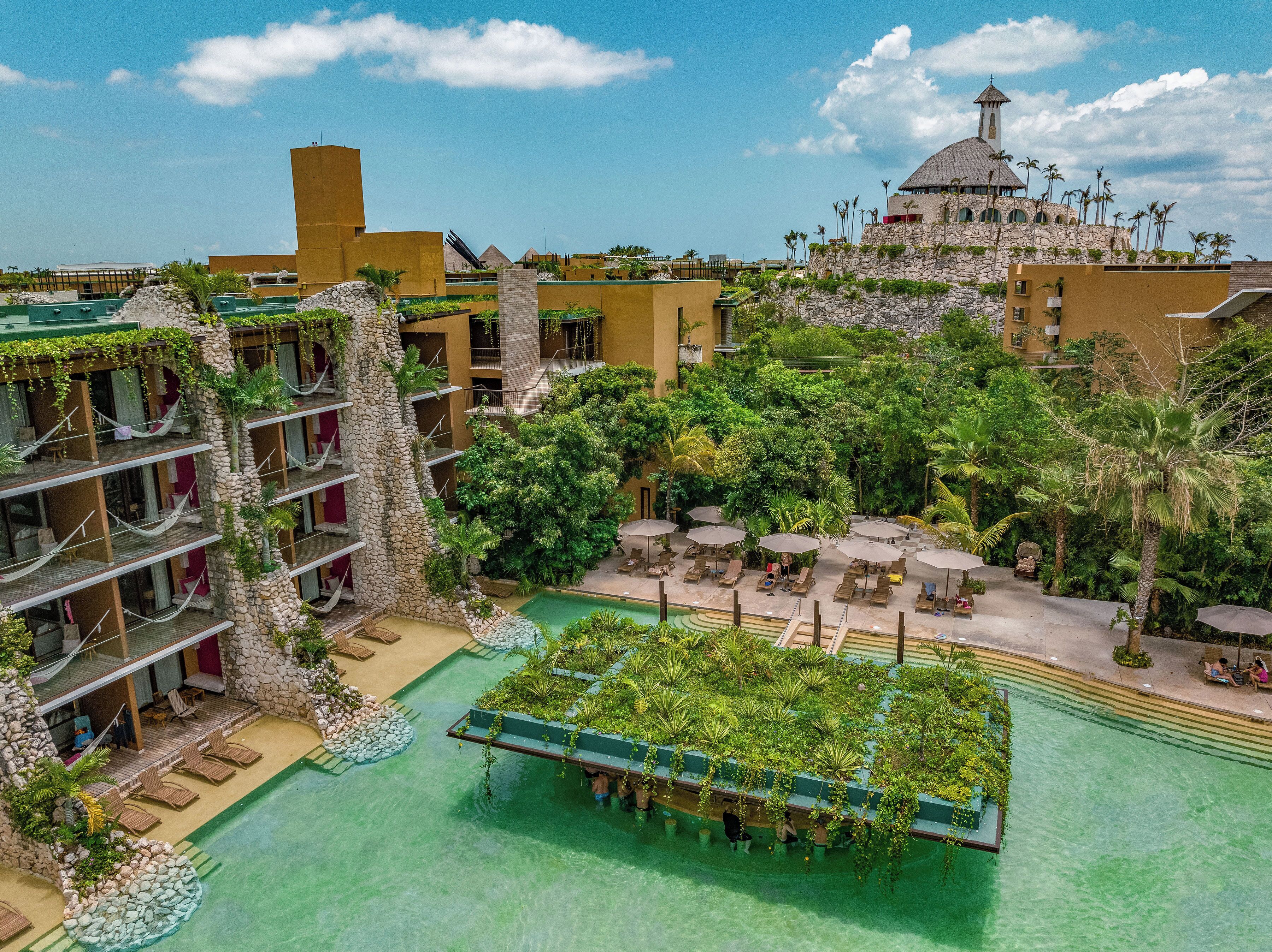 A resort with multiple floors, outdoor pools, and lush greenery.