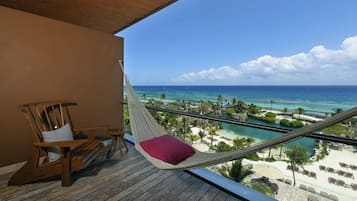 Una hamaca en un balcón con vistas a una playa y cielos despejados.