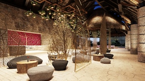 An indoor space with stone walls, hanging plants, and modern seating arrangements. - Hotel Xcaret Tierra - Family Premier - All inclusive (Playa del Carmen)