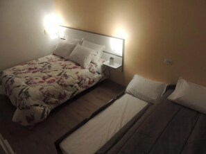Une chambre à coucher avec un lit, une table de chevet et une commode.