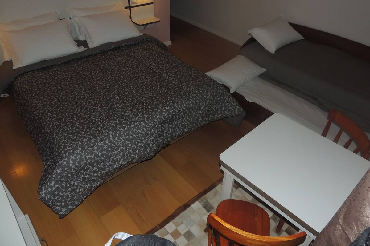 Une chambre à coucher avec un lit, une table de chevet, une chaise et un canapé.