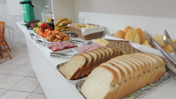 Un bufé con distintos alimentos, entre ellos pan, frutas y pastelería.