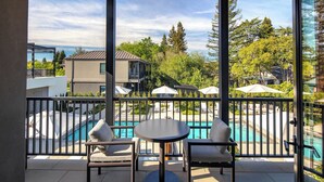 A balcony with a pool view, outdoor seating, and a railing. - Duchamp Healdsburg (Healdsburg)