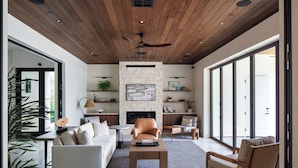 A modern living room with a fireplace, wooden ceiling, and large windows. - Duchamp Healdsburg (Healdsburg)
