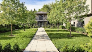 A pathway leading to a building with a covered entrance and a balcony. - Duchamp Healdsburg (Healdsburg)