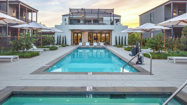 A swimming pool with lounge chairs and umbrellas, surrounded by modern buildings. - Duchamp Healdsburg (Healdsburg)