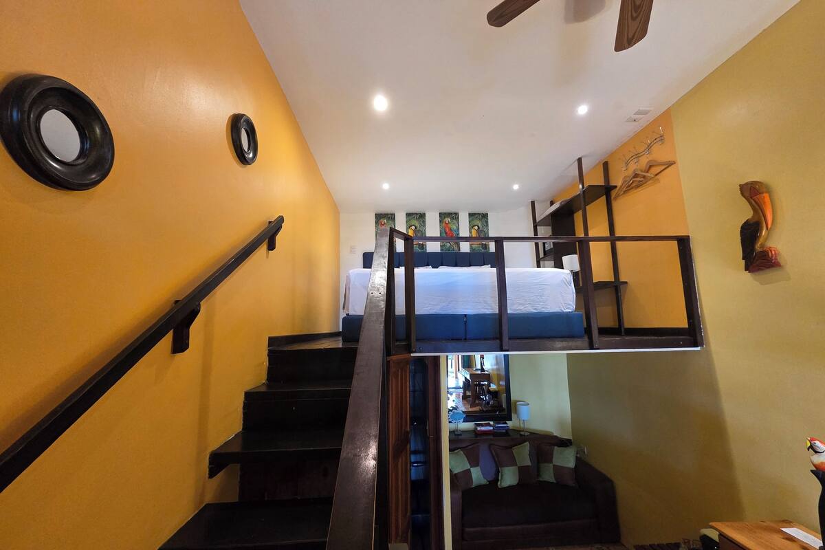 A staircase leading to a bunk bed room with a television in the background.