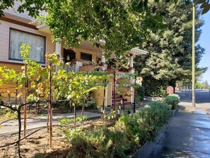 A residential house with a front yard, a pergola, and a small garden. - Cabernet House, An Old World Inn (Napa)