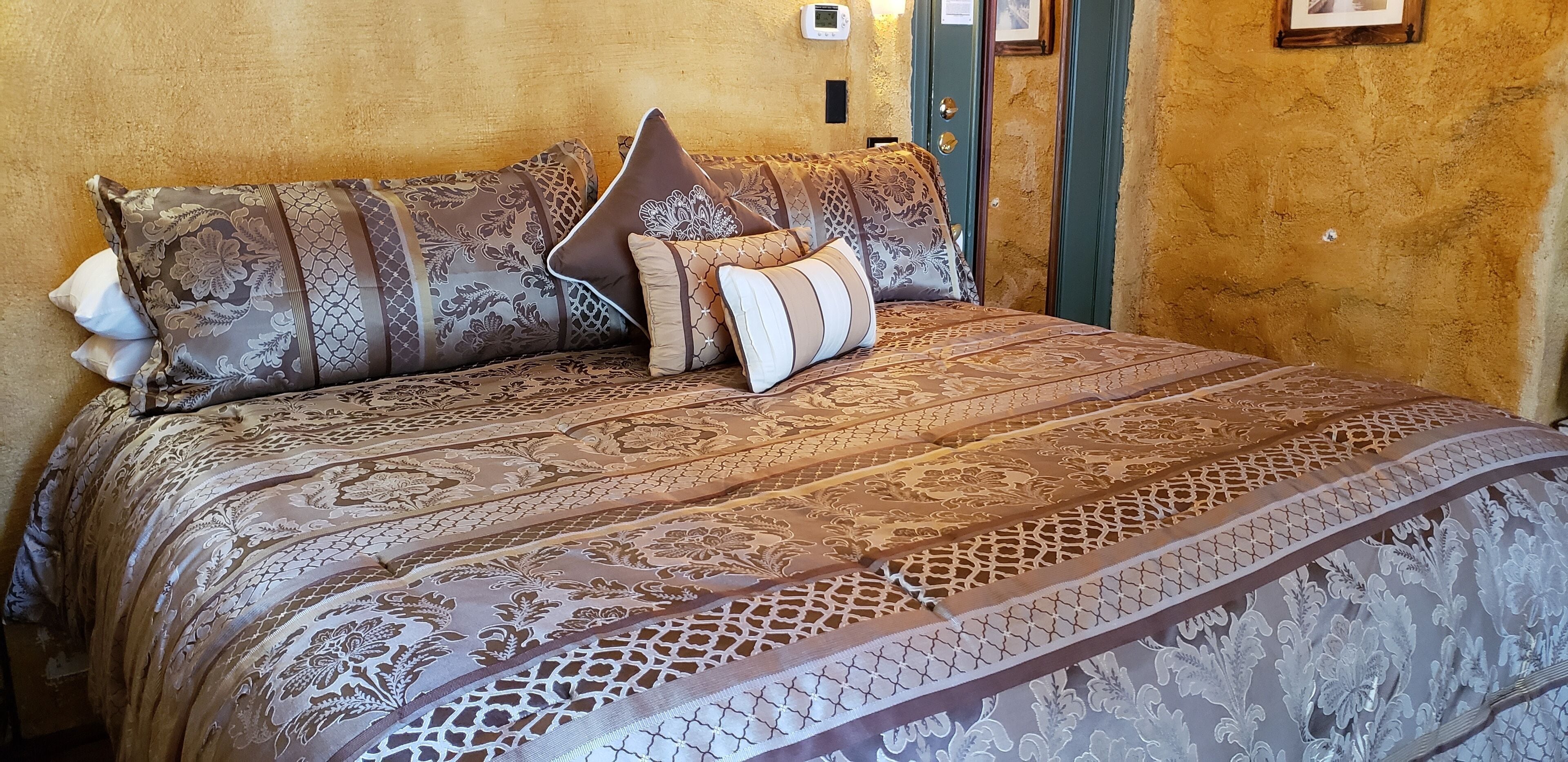 A bed with patterned bedding and multiple pillows.