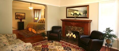 A living room with a fireplace, a sofa, a chair, and a large rug.