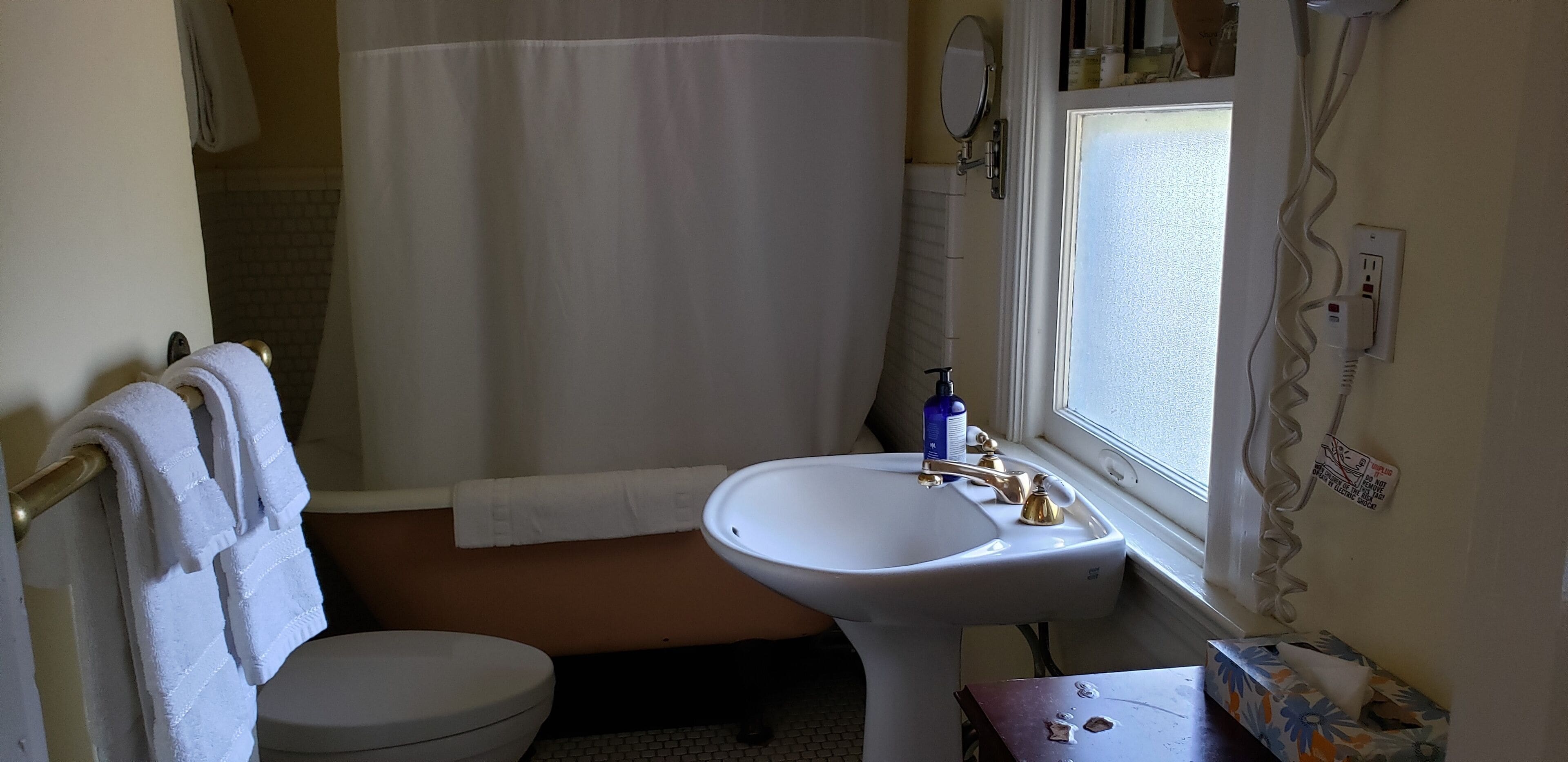 A bathroom with a toilet, sink, and shower area.