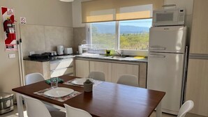 Una cocina compacta con comedor, un refrigerador y vistas al exterior.
